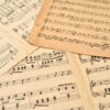 Old sheets with music notes scattered on the table. Close-up. Retro style. Selective focus.